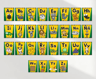 Tarjetas alfabéticas con letras mayúsculas y minúsculas en español, cada una con un animal u objeto de dibujos animados que empieza por la letra, sobre fondos amarillos y verdes. Incluye "Ch", "Ll", "Ñ" específicas del español.